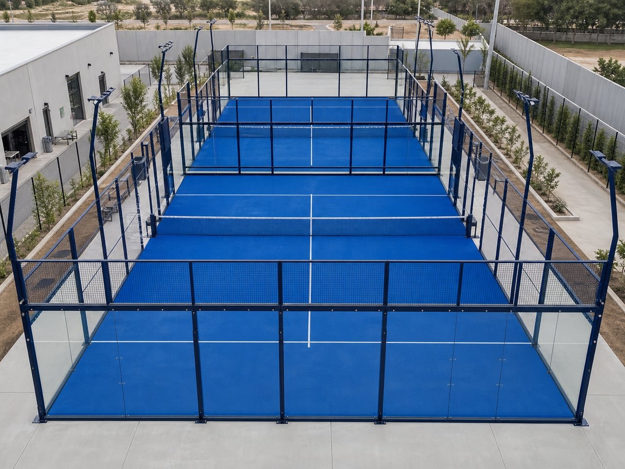 Three matching standard framed padel courts arranged for a commercial multi-court facility.